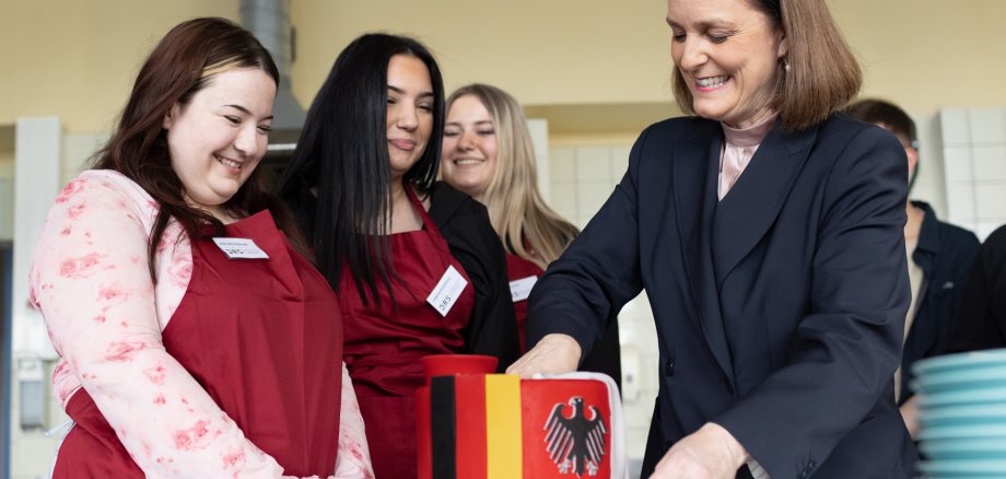Frau Dr. Emmenegger schneidet eine Geburtstagstorte an.