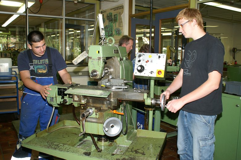 zwei Schüler arbeiten an einer metalltechnischen Maschine.