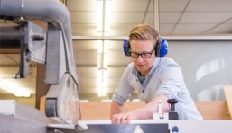 Schüler arbeitet an einer Tischkreissäge.