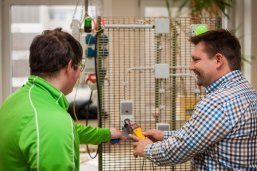 Lehrer erklärt Schüler technische Funktionen einer elektrischen Schaltung