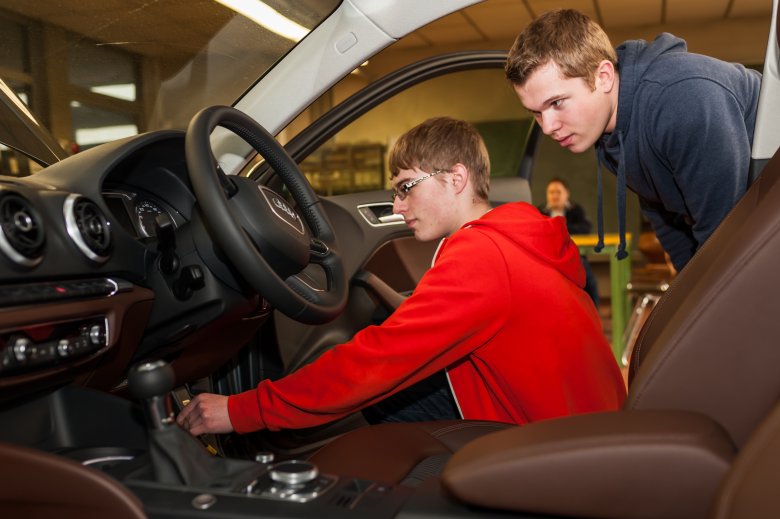 Zwei Schüler überprüfen den Innenraum eines Audi.