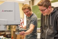 Zwei Schüler kontrollieren ein mechtatronisches Bauteil.